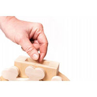 Hand legt ein Leckerli in das interaktive Pet's Clock Puzzle, ein geistiges Spielzeug für Hunde zur Förderung der Problemlösungsfähigkeiten.