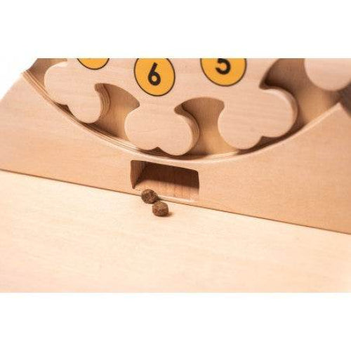 Zwei Hundesnacks fallen aus dem Pet's Clock Puzzle, einem interaktiven Spielzeug für Hunde zur geistigen Stimulation und Problemlösungsförderung.