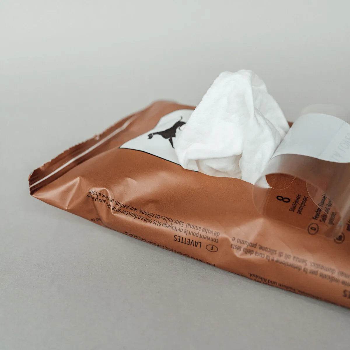 Geöffnete Verpackung von LILA LOVES IT LAVETTES – feuchte Reinigungshandschuhe für Hunde und Katzen, mit Aloe Vera angereichert und ideal für unterwegs.