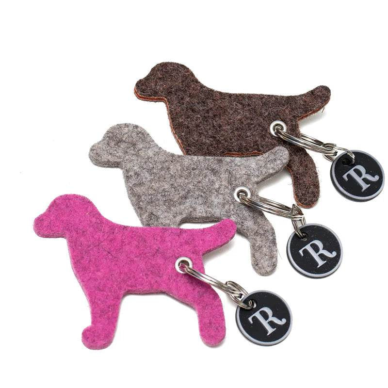Handgefertigter Schlüsselanhänger aus 100% Wollfilz mit abnehmbarem Klimperschutz für Hundemarken. Weich, schmutzabweisend, wasserfest und in liebevoller Handarbeit in einer Werkstatt für Menschen mit Behinderung gefertigt. In verschiedenen Naturfarben erhältlich.